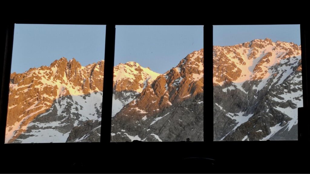 View of a mountain sunrise seen through a window.